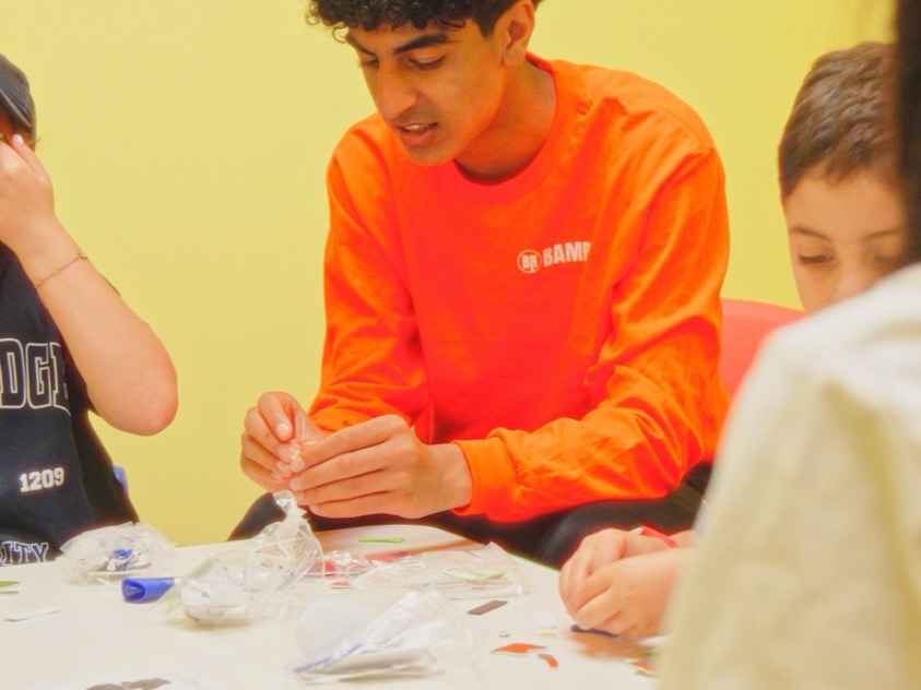 A Bamrec mentor running a craft table with children